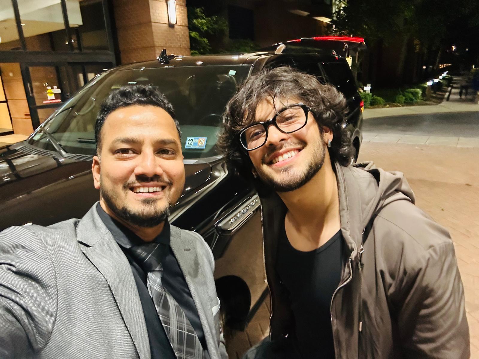 Chauffeur with a client at night beside the vehicle